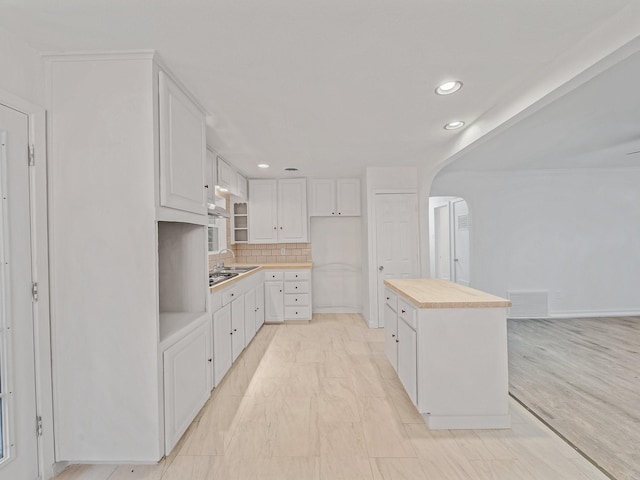 5537 Wheaton Dr, Fort Worth, TX 76133 - kitchen featuring butcher block countertops, arched walkways, white cabinets, backsplash, and recessed lighting