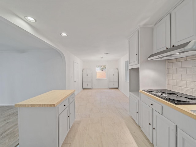 5537 Wheaton Dr, Fort Worth, TX 76133 - kitchen with electric cooktop, under cabinet range hood, wooden counters, a chandelier, and decorative backsplash