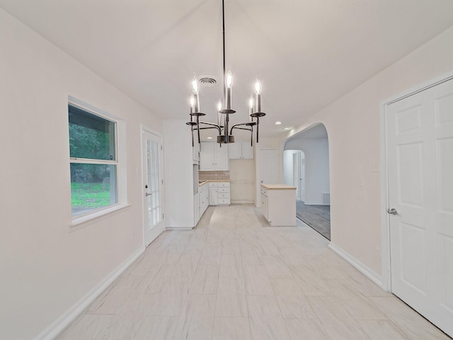 5537 Wheaton Dr, Fort Worth, TX 76133 - unfurnished dining area with arched walkways and a chandelier