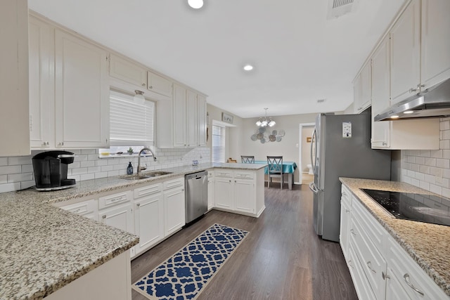 7329 Yolanda Dr, Fort Worth, TX 76112 - kitchen with stainless steel appliances, a peninsula, tasteful backsplash, a chandelier, and white cabinets