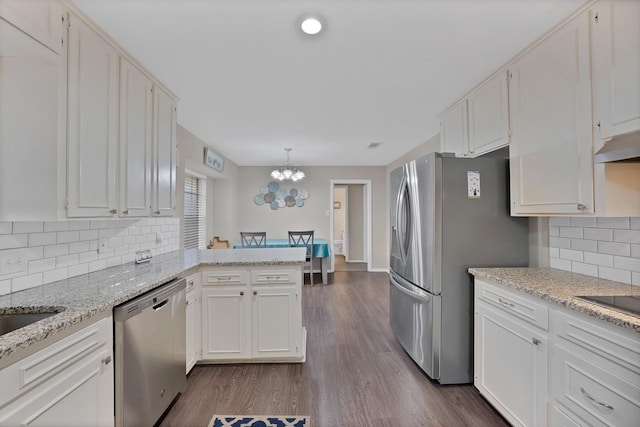 7329 Yolanda Dr, Fort Worth, TX 76112 - kitchen featuring stainless steel appliances, a chandelier, a peninsula, white cabinets, and dark wood finished floors
