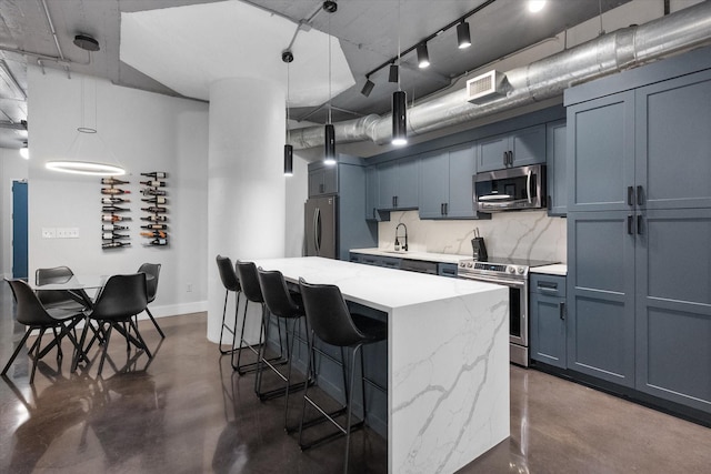 1122 Jackson St Unit 418, Dallas, TX 75202 - kitchen with appliances with stainless steel finishes, concrete floors, a kitchen bar, a kitchen island, and hanging light fixtures