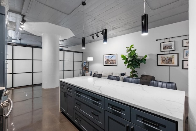 1122 Jackson St Unit 418, Dallas, TX 75202 - kitchen featuring finished concrete flooring, light stone countertops, open floor plan, and ornate columns