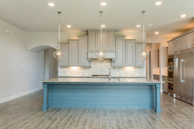 9714 Minister Ln, Frisco, TX 75035 - kitchen with built in appliances, light wood-style floors, decorative backsplash, and recessed lighting