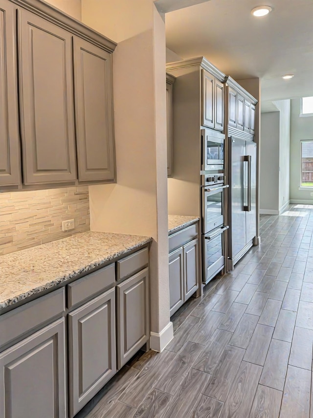 9714 Minister Ln, Frisco, TX 75035 - kitchen with stainless steel appliances, gray cabinets, backsplash, recessed lighting, and wood finished floors