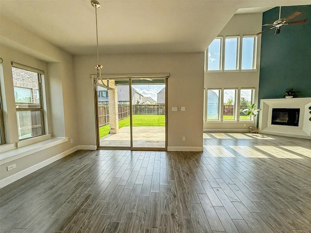 9714 Minister Ln, Frisco, TX 75035 - unfurnished living room featuring dark wood-style flooring, ceiling fan, and a glass covered fireplace