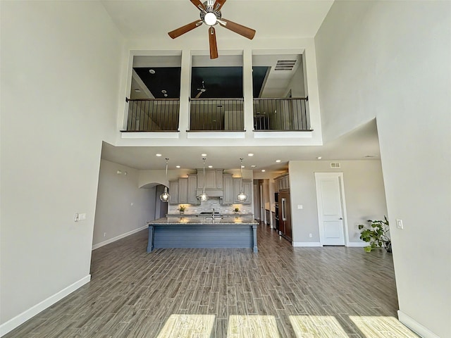 9714 Minister Ln, Frisco, TX 75035 - unfurnished living room featuring a ceiling fan, wood finished floors, and a towering ceiling
