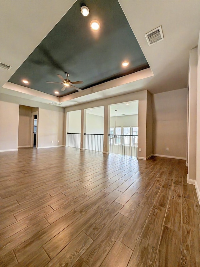 9714 Minister Ln, Frisco, TX 75035 - unfurnished living room with a raised ceiling, ceiling fan, wood finished floors, and recessed lighting