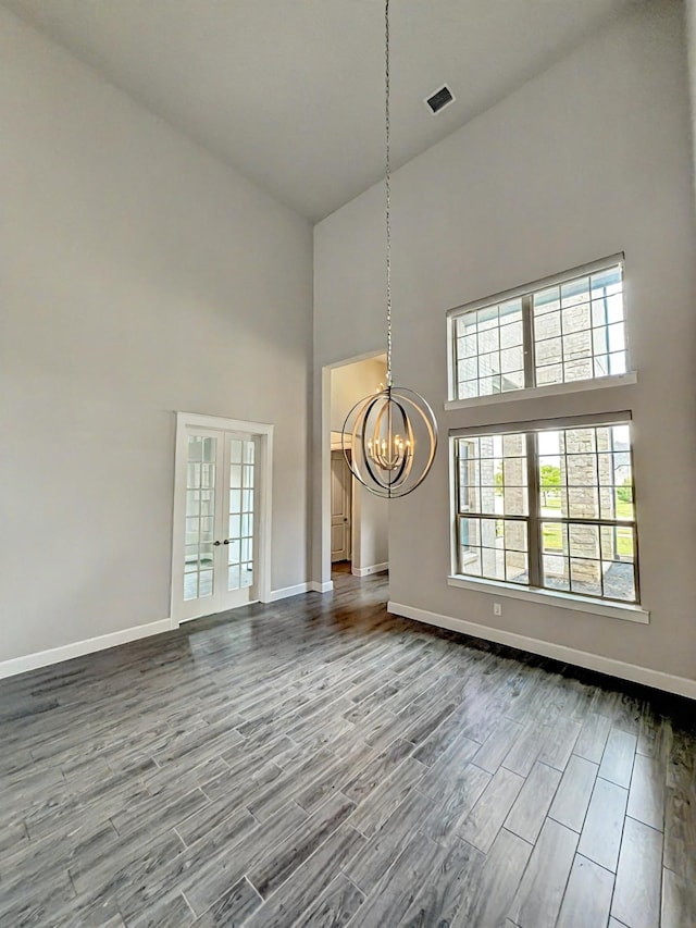 9714 Minister Ln, Frisco, TX 75035 - unfurnished living room with a towering ceiling, a chandelier, wood finished floors, and french doors