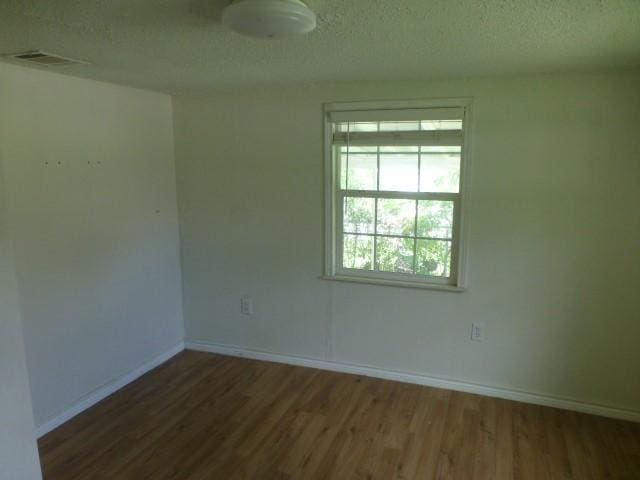 408 Soward Ave, Weatherford, TX 76086 - unfurnished room with wood finished floors and a textured ceiling