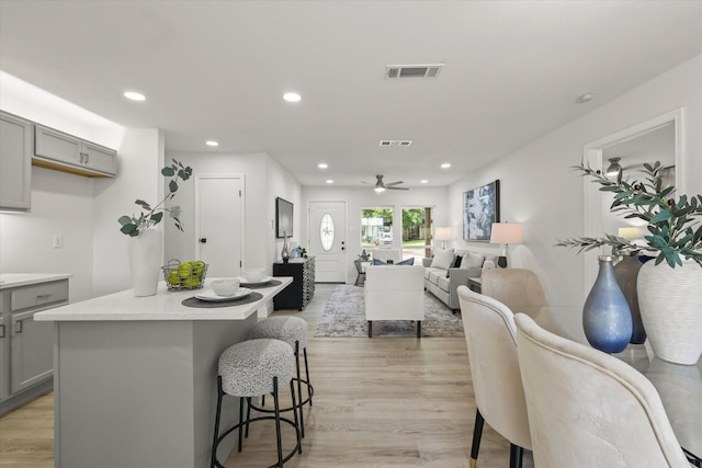 1843 Trent Dr, Arlington, TX 76010 - kitchen with gray cabinets, recessed lighting, light wood finished floors, and a kitchen bar