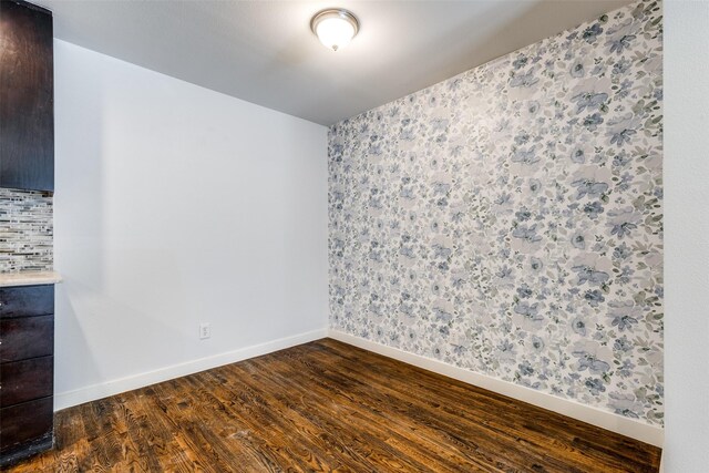 5816 Birchbrook Dr Unit 122, Dallas, TX 75206 - spare room featuring dark wood-style flooring and wallpapered walls