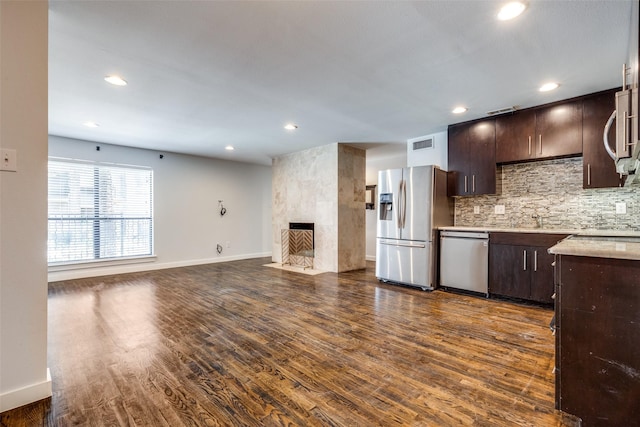 5816 Birchbrook Dr Unit 122, Dallas, TX 75206 - kitchen featuring appliances with stainless steel finishes, dark brown cabinetry, backsplash, light countertops, and recessed lighting