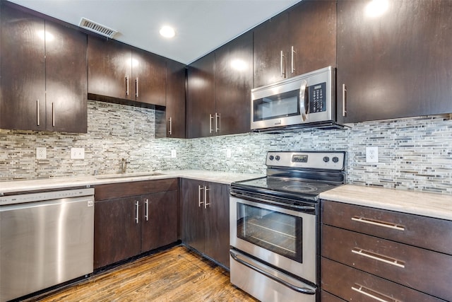 5816 Birchbrook Dr Unit 122, Dallas, TX 75206 - kitchen featuring stainless steel appliances, light countertops, light wood-style floors, and dark brown cabinetry