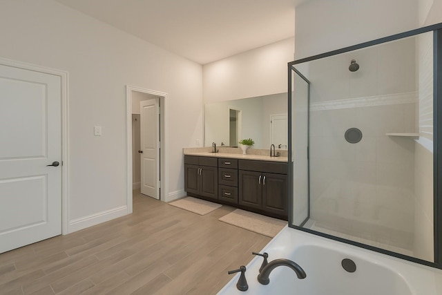 617 Saragosa Ct, Mckinney, TX 75071 - bathroom featuring double vanity, a garden tub, a stall shower, and wood finished floors