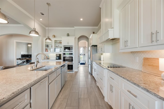 11088 Whispering Ln, Talty, TX 75126 - kitchen featuring arched walkways, stainless steel appliances, ornamental molding, white cabinetry, and backsplash