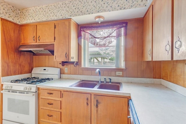 509 Lipscomb St, Bonham, TX 75418 - kitchen with white range with gas stovetop, under cabinet range hood, light countertops, and brown cabinets
