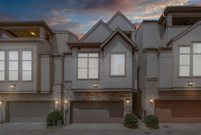 5184 Brickellia, Dallas, TX 75209 - view of property with stucco siding, a garage, driveway, and stone siding
