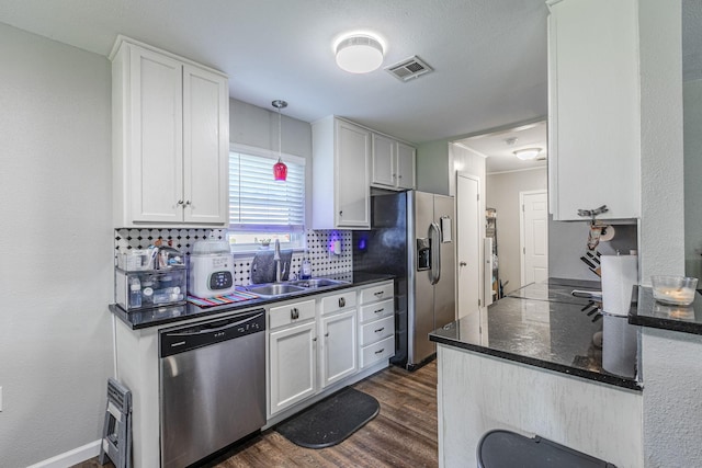 3401 Medallion Cir, Waco, TX 76706 - kitchen with appliances with stainless steel finishes, white cabinets, dark wood-style flooring, and pendant lighting