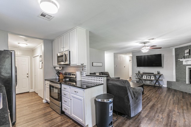 3401 Medallion Cir, Waco, TX 76706 - kitchen with appliances with stainless steel finishes, open floor plan, dark wood finished floors, a ceiling fan, and white cabinets