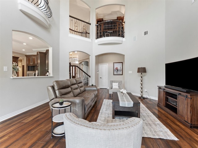 2 Pond View Ct, Mansfield, TX 76063 - living area featuring arched walkways, dark wood finished floors, stairway, a high ceiling, and recessed lighting