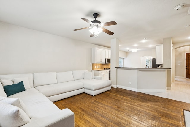2778 Hidden Knoll Trl, Frisco, TX 75034 - living room with arched walkways, a ceiling fan, and light wood-style floors
