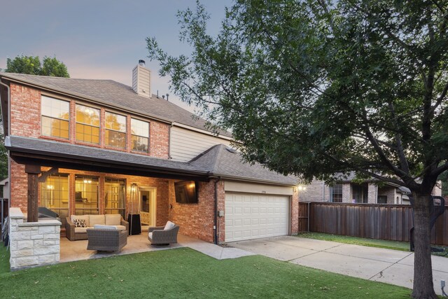 2778 Hidden Knoll Trl, Frisco, TX 75034 - back of property at dusk featuring an outdoor hangout area, brick siding, driveway, and a garage