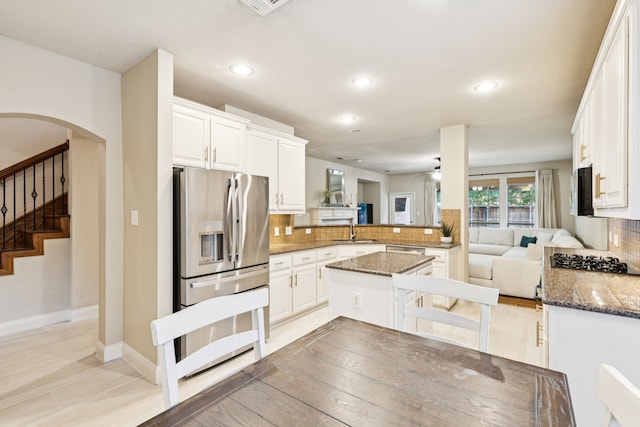 2778 Hidden Knoll Trl, Frisco, TX 75034 - kitchen with appliances with stainless steel finishes, a peninsula, decorative backsplash, recessed lighting, and dark stone counters