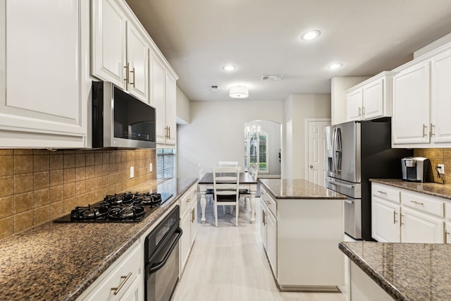 2778 Hidden Knoll Trl, Frisco, TX 75034 - kitchen featuring black appliances, arched walkways, white cabinets, backsplash, and recessed lighting