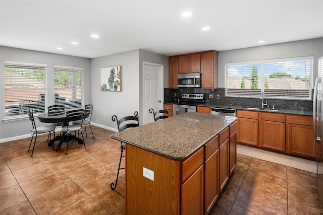 2115 Highland River Dr, Wylie, TX 75098 - kitchen with appliances with stainless steel finishes, recessed lighting, healthy amount of natural light, and brown cabinetry