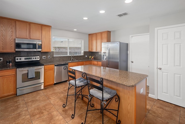 2115 Highland River Dr, Wylie, TX 75098 - kitchen featuring stainless steel appliances, backsplash, a breakfast bar, recessed lighting, and dark stone countertops