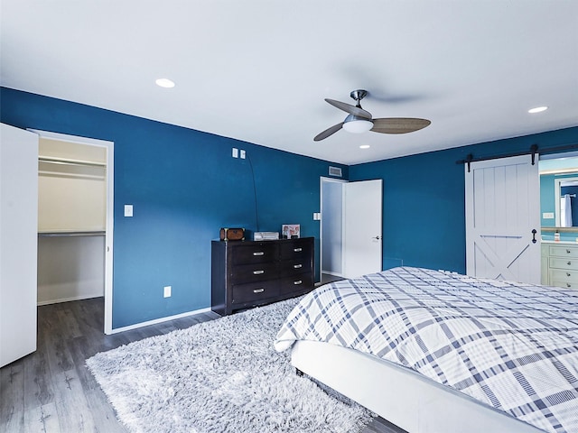 2032 Christie Ln, Carrollton, TX 75007 - bedroom featuring a barn door, wood finished floors, a closet, a walk in closet, and ceiling fan