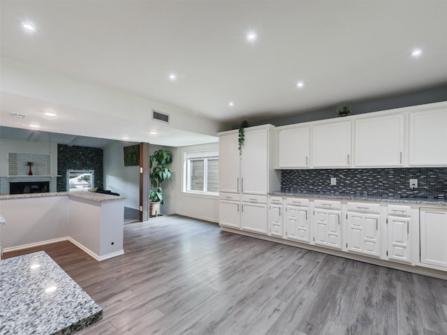 2032 Christie Ln, Carrollton, TX 75007 - kitchen with light wood-style flooring, tasteful backsplash, white cabinetry, open floor plan, and recessed lighting
