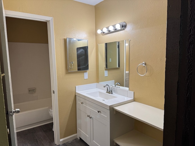 711 Ticonderoga Dr, Garland, TX 75043 - bathroom with wood finished floors, vanity, and a textured wall