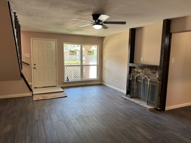 711 Ticonderoga Dr, Garland, TX 75043 - unfurnished living room featuring a brick fireplace, dark wood finished floors, ceiling fan, and a textured ceiling