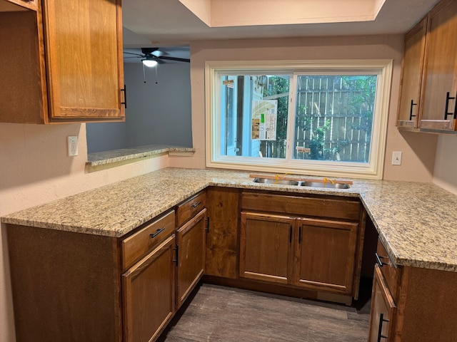 711 Ticonderoga Dr, Garland, TX 75043 - kitchen with a ceiling fan, light stone counters, and dark wood-style flooring