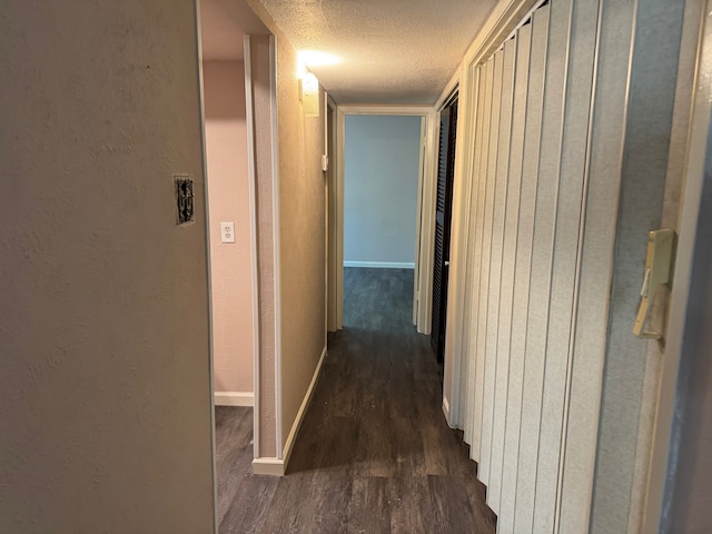 711 Ticonderoga Dr, Garland, TX 75043 - corridor featuring a textured ceiling, dark wood finished floors, and a textured wall