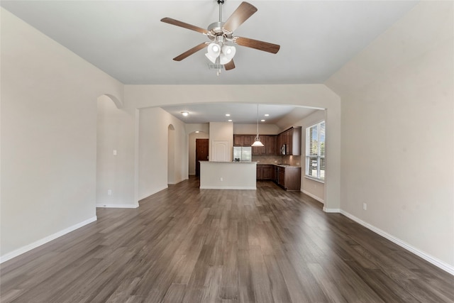 3408 Glen Crest Ln, Denton, TX 76208 - unfurnished living room featuring arched walkways, a ceiling fan, and dark wood finished floors
