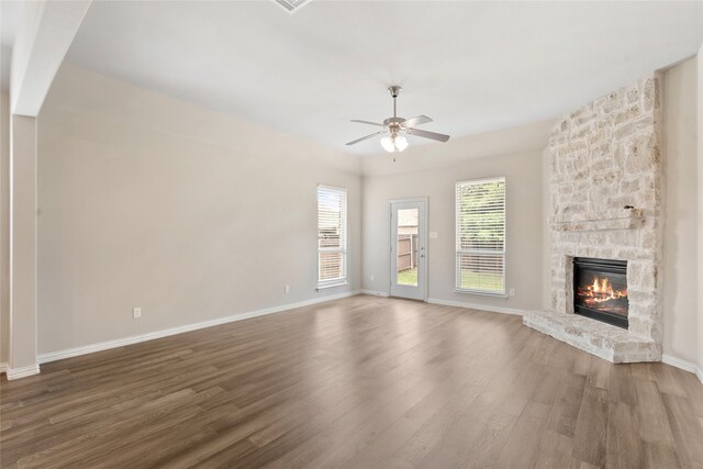 3408 Glen Crest Ln, Denton, TX 76208 - unfurnished living room with wood finished floors, a ceiling fan, and a stone fireplace