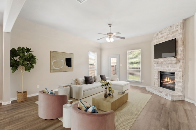 3408 Glen Crest Ln, Denton, TX 76208 - living room featuring wood finished floors, a stone fireplace, and ceiling fan