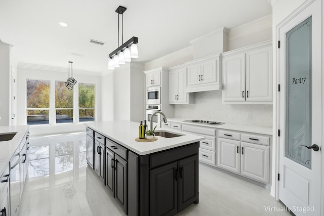 149 Silver Valley Ln, Fort Worth, TX 76108 - kitchen with white cabinetry, ornamental molding, light countertops, an island with sink, and decorative light fixtures