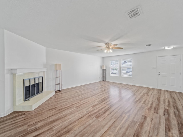 2321 Live Oak Dr, Little Elm, TX 75068 - unfurnished living room featuring light wood-style floors, ceiling fan, and a tile fireplace