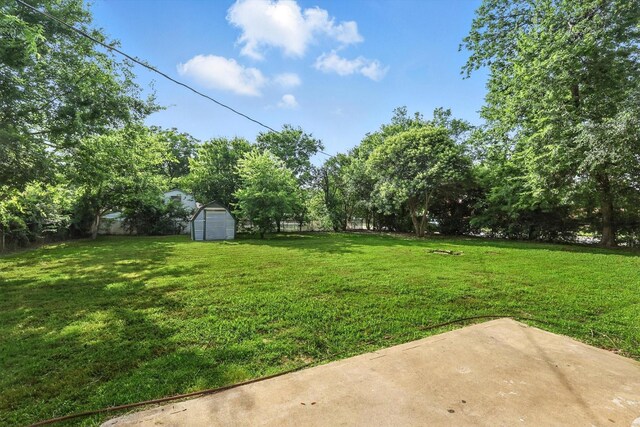 200 Arcadia St, Hurst, TX 76053 - view of grassy yard with a storage unit and a patio