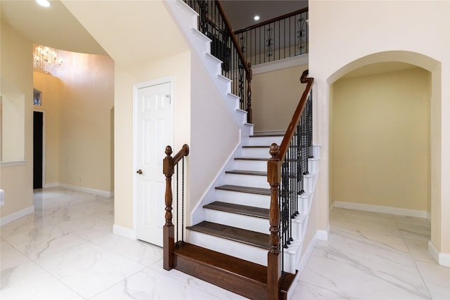 6608 Terrace Mill Ln, Plano, TX 75024 - stairs featuring marble tiled floors, arched walkways, a chandelier, a towering ceiling, and recessed lighting