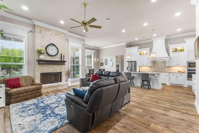 10309 Creekside Ln, Waco, TX 76712 - living room with plenty of natural light, a ceiling fan, light wood finished floors, a fireplace, and ornamental molding