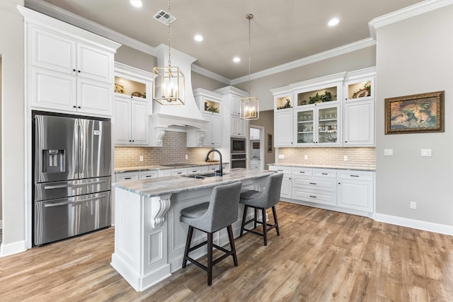 10309 Creekside Ln, Waco, TX 76712 - kitchen with appliances with stainless steel finishes, a chandelier, white cabinets, crown molding, and a kitchen island with sink