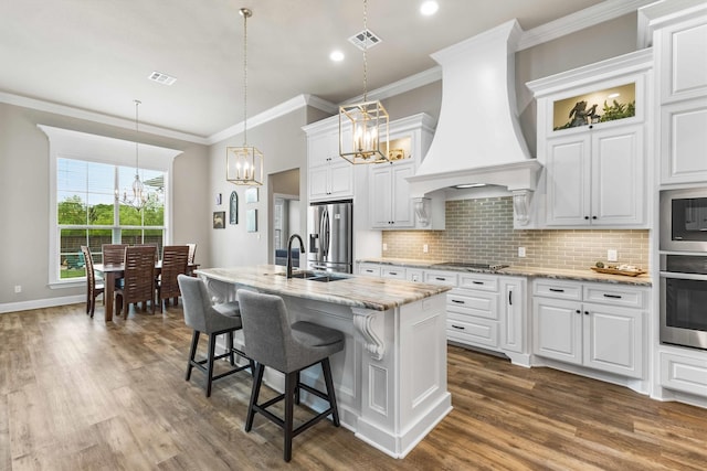 10309 Creekside Ln, Waco, TX 76712 - kitchen with stainless steel appliances, a chandelier, custom range hood, dark wood-type flooring, and crown molding