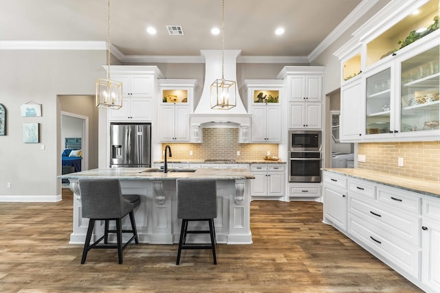 10309 Creekside Ln, Waco, TX 76712 - kitchen with stainless steel appliances, a kitchen bar, white cabinetry, an island with sink, and crown molding