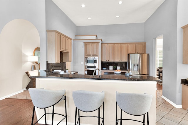 5405 Enfield Dr, Richardson, TX 75082 - kitchen featuring stainless steel appliances, light brown cabinets, a peninsula, backsplash, and a high ceiling