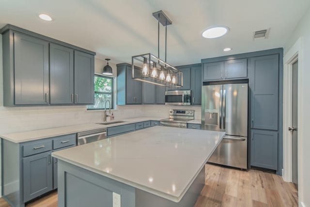 5209 Cordova Ave, Fort Worth, TX 76132 - kitchen with appliances with stainless steel finishes, tasteful backsplash, light countertops, light wood-type flooring, and pendant lighting